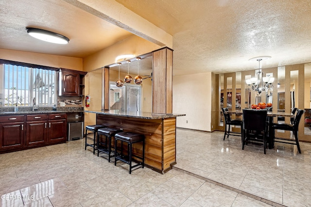 kitchen featuring hanging light fixtures, a kitchen breakfast bar, a chandelier, decorative backsplash, and a kitchen island