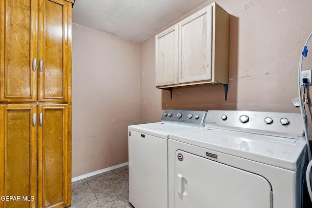 laundry room featuring light tile patterned flooring, cabinets, a textured ceiling, and independent washer and dryer