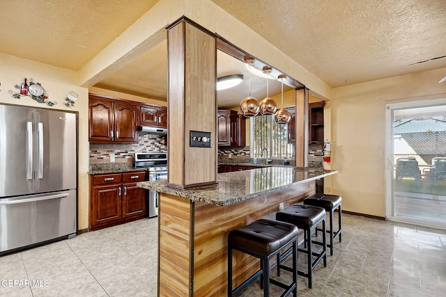 kitchen featuring a breakfast bar area, tasteful backsplash, stainless steel appliances, and plenty of natural light