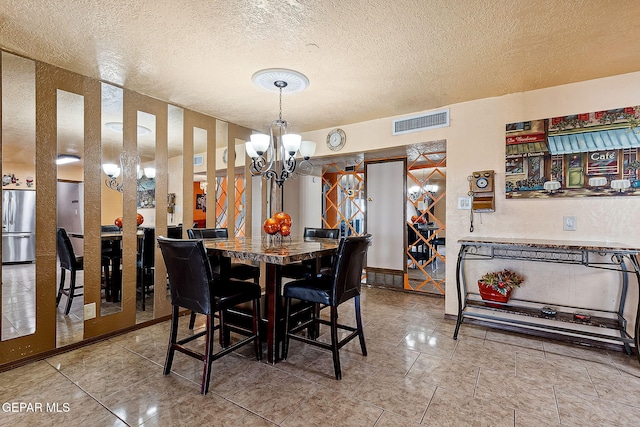 dining room with a notable chandelier and a textured ceiling