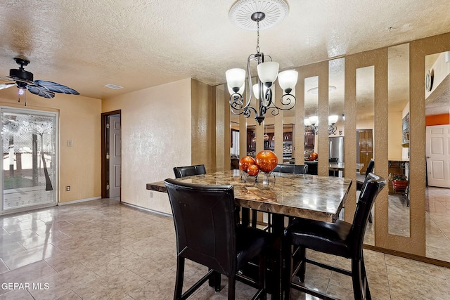 dining space featuring ceiling fan with notable chandelier and a textured ceiling