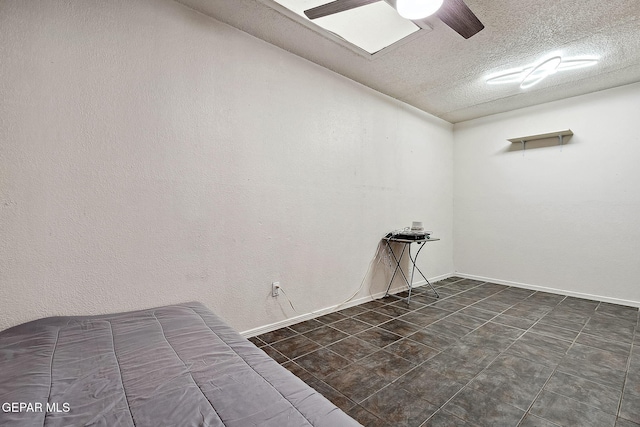 interior space with a textured ceiling and ceiling fan