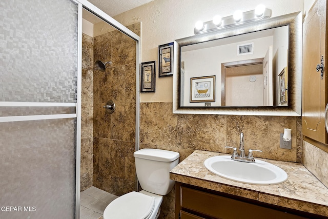 bathroom with vanity, toilet, walk in shower, and tile walls