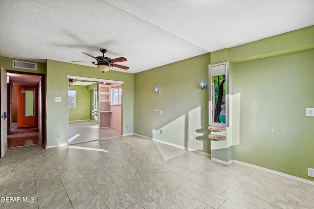 spare room featuring ceiling fan and a textured ceiling