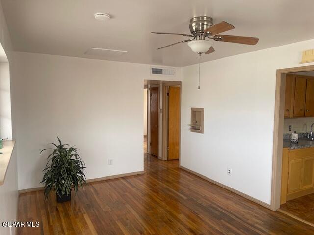 spare room featuring ceiling fan and dark wood-type flooring