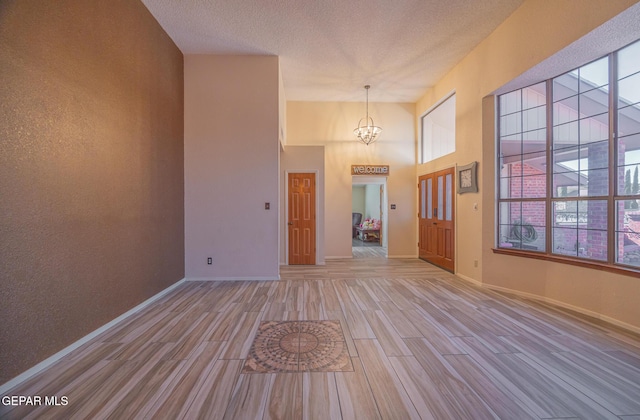 spare room featuring light wood-type flooring, plenty of natural light, and a textured ceiling