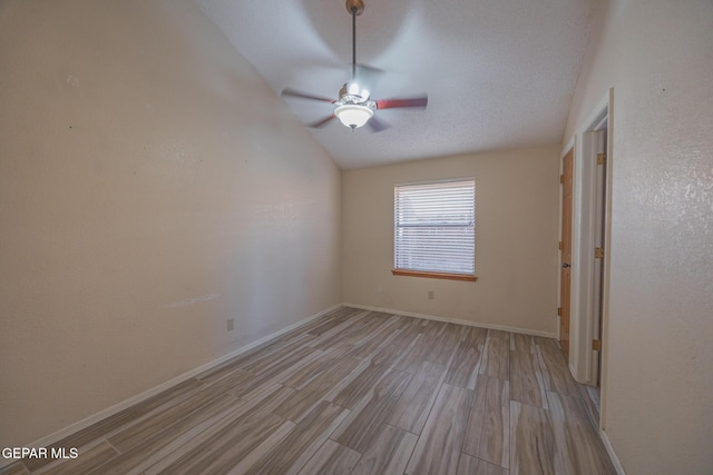 unfurnished bedroom featuring light wood-type flooring, vaulted ceiling, a textured ceiling, and baseboards