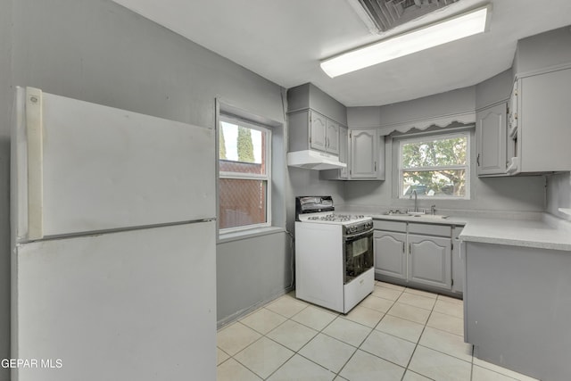 kitchen with light tile patterned floors, white appliances, gray cabinets, and sink