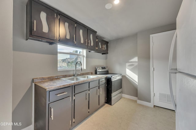 kitchen featuring white fridge, stainless steel electric stove, and sink