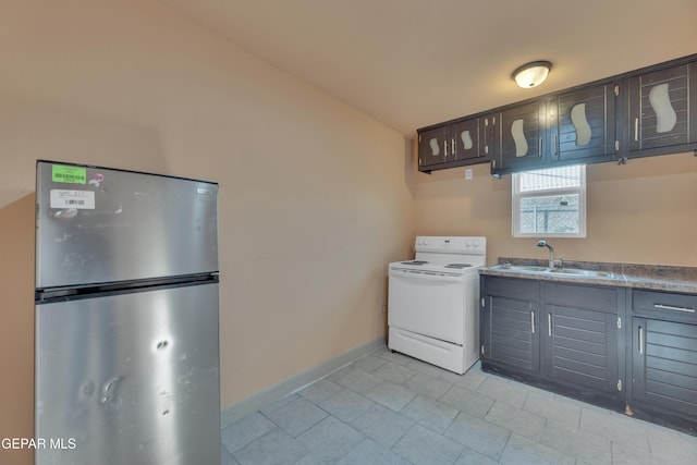 kitchen with white range with electric cooktop, stainless steel fridge, and sink