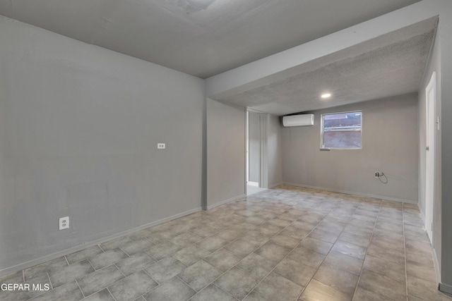 unfurnished room featuring a textured ceiling and an AC wall unit