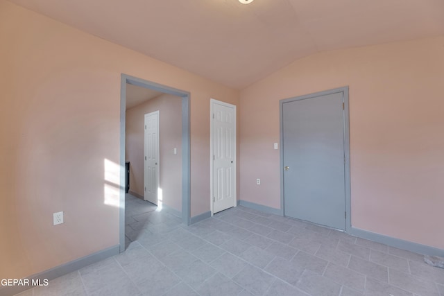 empty room featuring vaulted ceiling