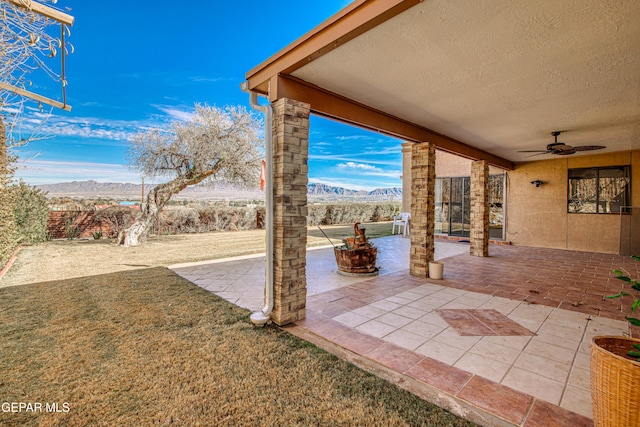 view of patio / terrace featuring a mountain view and ceiling fan