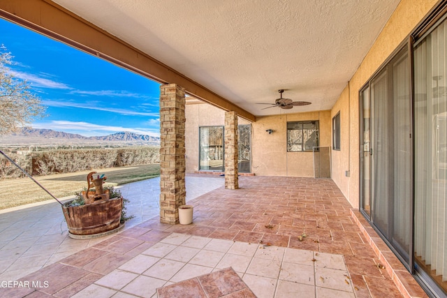 view of patio / terrace with a mountain view and ceiling fan