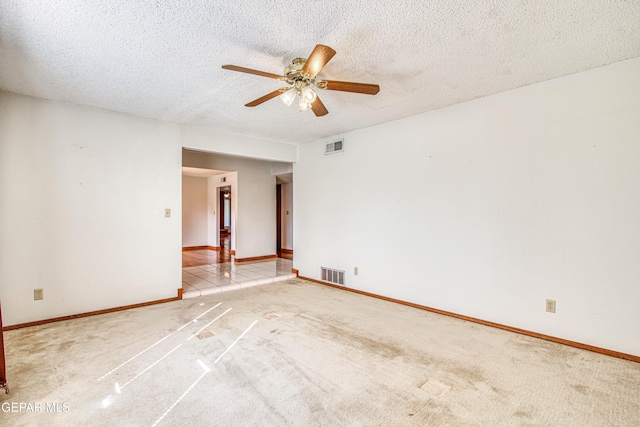 carpeted spare room with ceiling fan and a textured ceiling