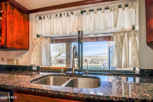 kitchen with dark stone countertops, sink, and a mountain view