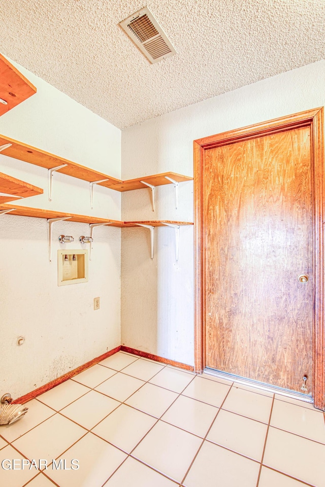 spacious closet with light tile patterned floors