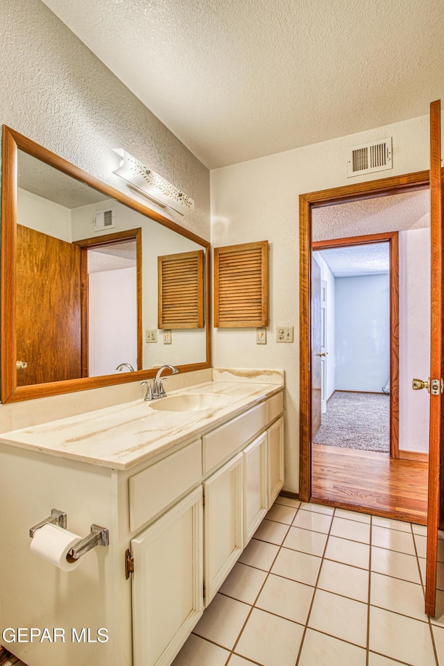 bathroom featuring tile patterned floors, a textured ceiling, and vanity