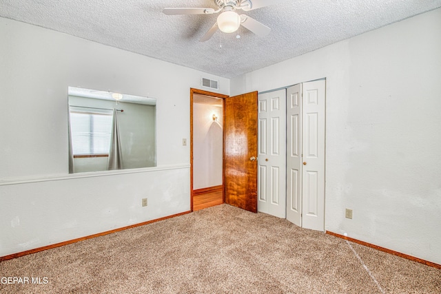 unfurnished bedroom featuring ceiling fan, a closet, carpet floors, and a textured ceiling