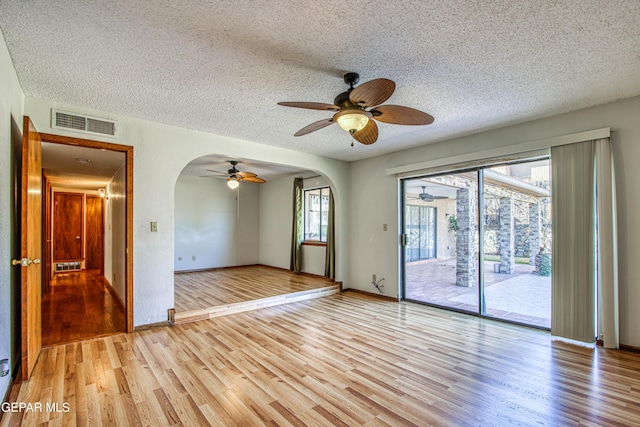 empty room with a textured ceiling and light wood-type flooring