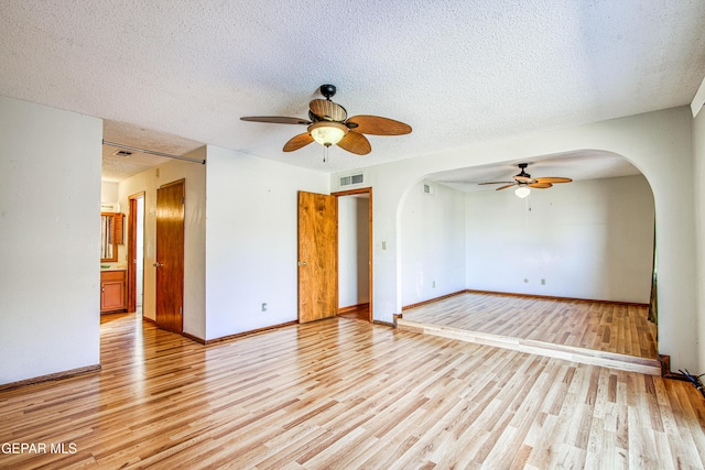 spare room with ceiling fan, a textured ceiling, and light hardwood / wood-style floors