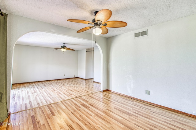 spare room featuring ceiling fan, a textured ceiling, and light wood-type flooring