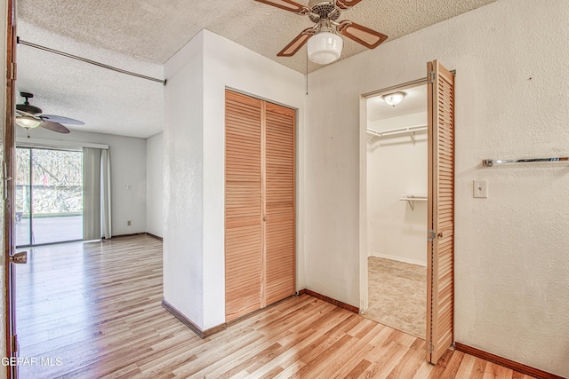 unfurnished bedroom featuring ceiling fan, light hardwood / wood-style floors, a closet, and a textured ceiling