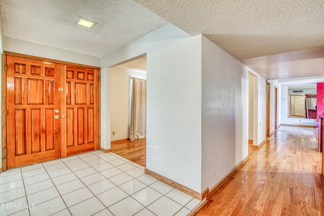 entrance foyer with a textured ceiling and light wood-type flooring