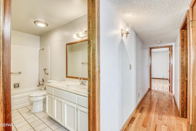 interior space featuring hardwood / wood-style flooring, vanity, a textured ceiling, and toilet