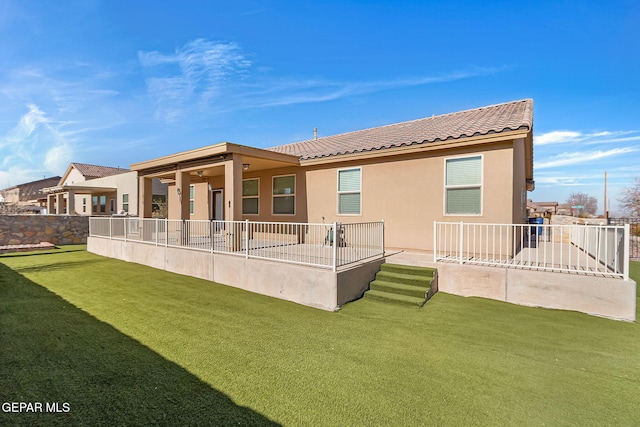 rear view of property with a lawn, ceiling fan, and a patio