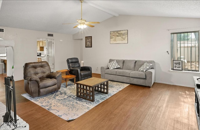 living room featuring hardwood / wood-style floors, lofted ceiling with beams, a textured ceiling, and ceiling fan