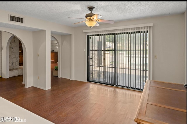 empty room with hardwood / wood-style flooring, ceiling fan, and a textured ceiling