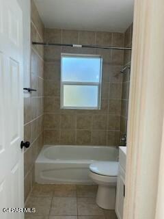 full bathroom featuring tile patterned floors, tiled shower / bath combo, toilet, and vanity