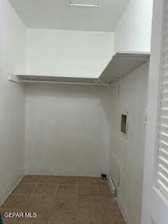 washroom with hookup for a washing machine and dark tile patterned flooring