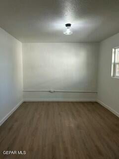 spare room featuring dark wood-type flooring