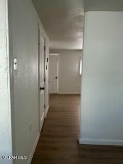 hallway with dark hardwood / wood-style flooring