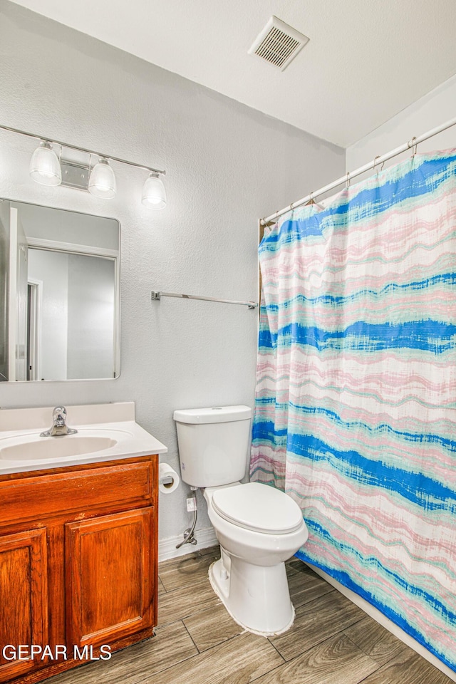 bathroom featuring a shower with shower curtain, vanity, and toilet