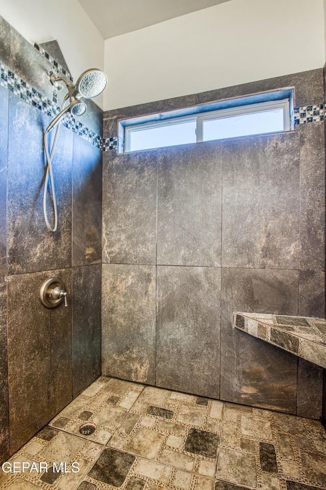 bathroom featuring a tile shower and a healthy amount of sunlight