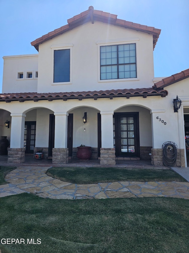 mediterranean / spanish-style home featuring a patio area and french doors