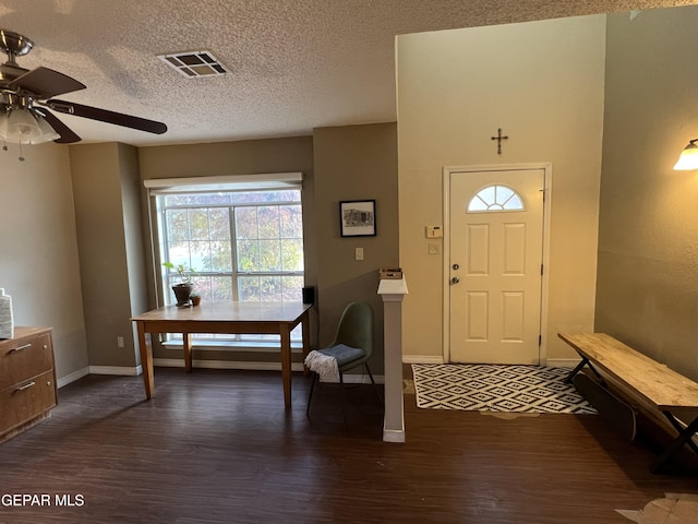 foyer entrance with a textured ceiling, dark hardwood / wood-style floors, and ceiling fan