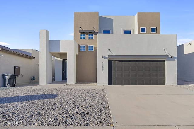 pueblo revival-style home featuring a garage