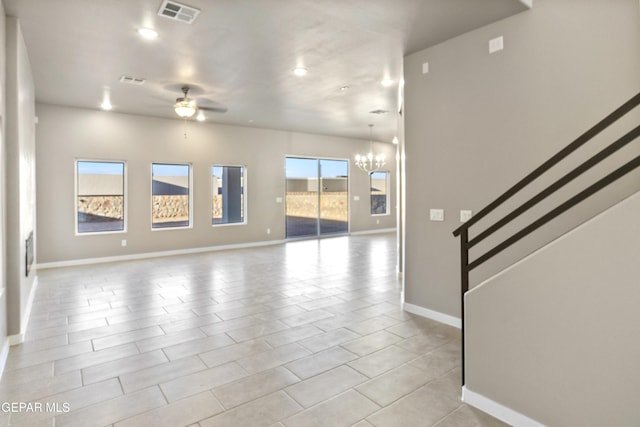 unfurnished living room with ceiling fan with notable chandelier