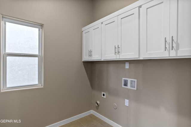 laundry room with gas dryer hookup, cabinets, washer hookup, light tile patterned floors, and electric dryer hookup