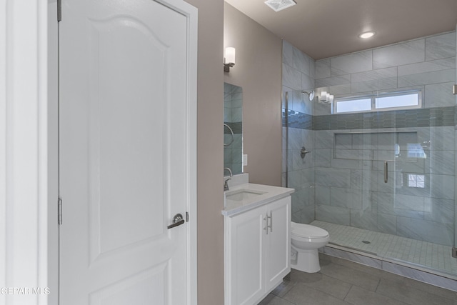 bathroom featuring walk in shower, vanity, toilet, and tile patterned flooring