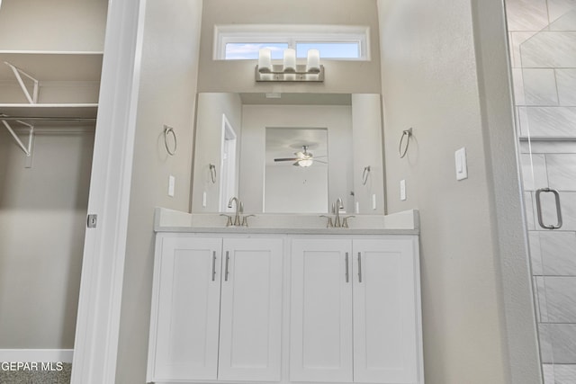 bathroom featuring a shower with door, vanity, and ceiling fan