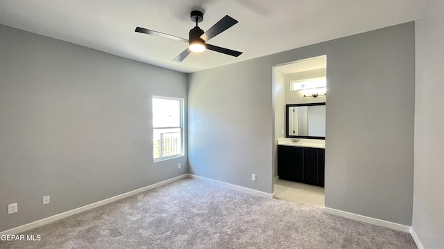 unfurnished bedroom featuring light carpet and ensuite bath