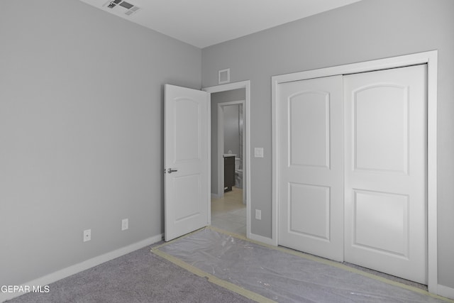 unfurnished bedroom featuring carpet flooring and a closet