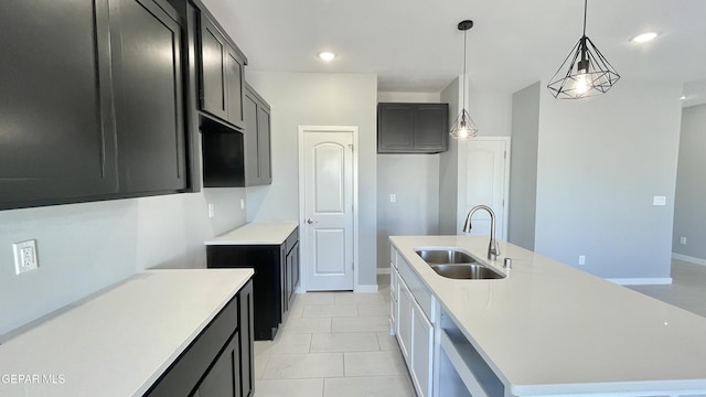 kitchen with light tile patterned floors, sink, pendant lighting, and a center island with sink