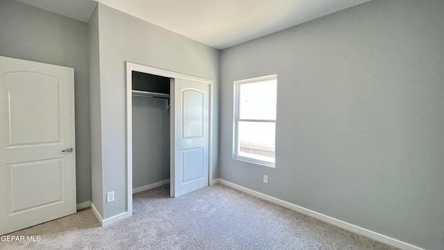 unfurnished bedroom featuring a closet and light carpet