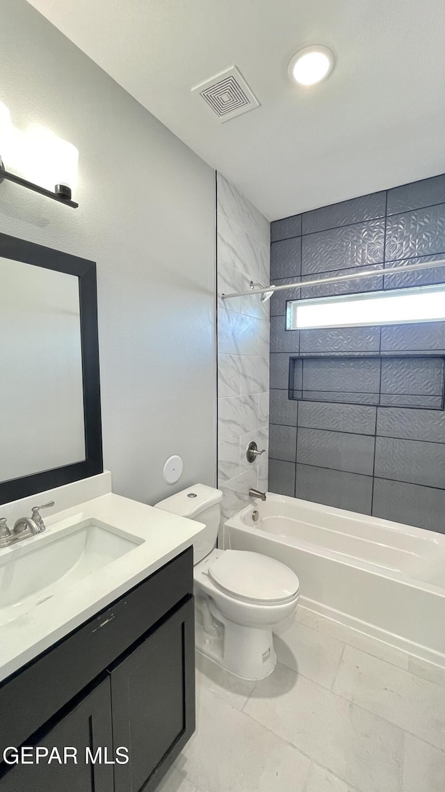 full bathroom featuring toilet, tiled shower / bath combo, and vanity